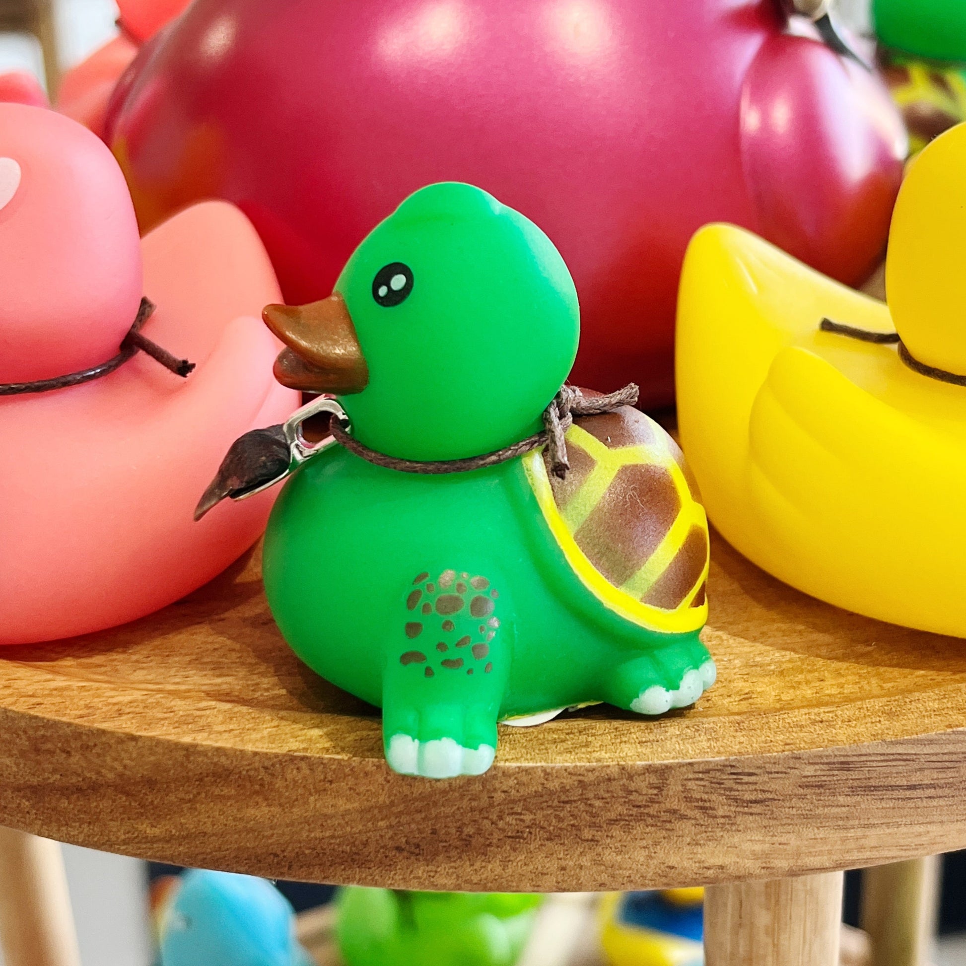Colorful rubber duck toys on a wooden surface with a blurred background